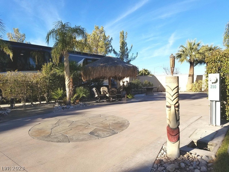 Located within the Class A Las Vegas Motorcoach Resort, this attractive south facing site has beautiful sago palms, stamped concrete pad, golf cart parking, palapa w/ table, patio furniture, fire pit, hand carved tiki and more!