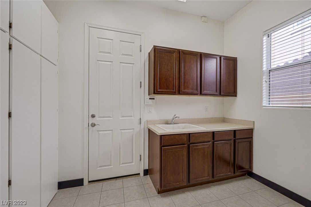 Laundry room with sink and cabinets. Entryway to the garage. 3D tour available through matterport!