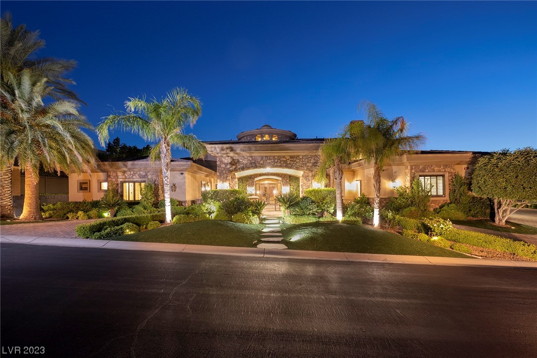 Spectacular MacDonald Highlands Estate situated on a premier lot overlooking the 18th green, Dragon Ridge Club House, and Las Vegas Strip! This home features a circular driveway with portico leading to a courtyard entry. Once inside you'll fine a grand foyer with 28' ceiling, dual 21 step staircases, a formal living room/fireplace and 22' long formal dining room. The chef’s kitchen boasts 2 islands, Wolf stove, 2 Subzero refrigerators, 13' kitchen nook with circular pocket doors, wet bar and built in fish tank. Family room w/ entertainment wall, 16' pocket doors, and walk-in wine cellar. 3 bedroom suites are located downstairs, along w/ a fitness room, dry sauna, massage and spa rooms. This home also features an elevator, 3 upstairs bedroom suites along w/ theater room, and 2 expansive balconies. Outside you'll find an in-ground pool/spa with iron gate, multiple patios, and synthetic grass. This smart home is run by a Creston system that functions electric shades, lights, TV's & HVAC.