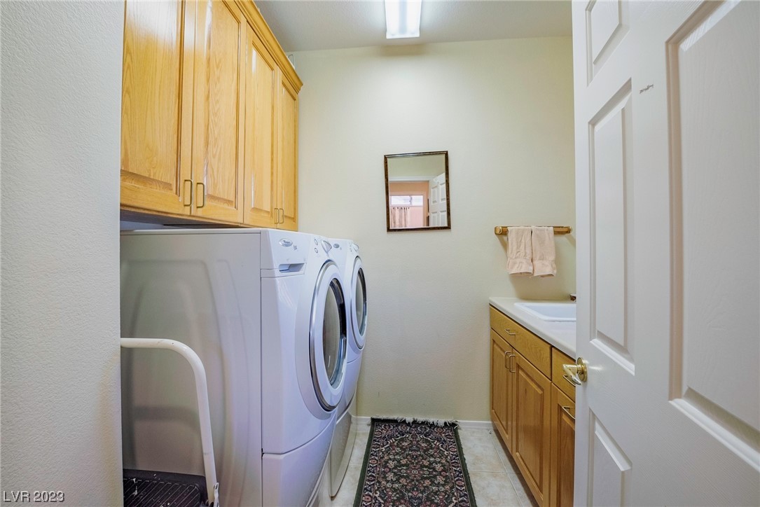 Large laundry room with cabinets and utility sink.