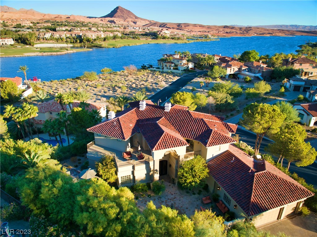 RARE AND MAGNIFICENT, THIS  LUXURY HOME COMES FURNISHED AND READY TO LIVE IN. SITUATED ON A HUGE CORNER LOT .43 WHICH WRAPS AROUND TO VIEW STUNNING VISTAS OF LAKE LAS VEGAS. When entering the home you will experience comfort and warmth throughout this 6127 sqft home, indulgent and large spacious living areas are an entertainer's delight. 2 Primary bedroom suites both up and down have steam spas. Every bedroom is an ensuite with a balcony, fireplace, and layers of luxury for guests to enjoy. Organic light flows throughout the home all day. The kitchen is customized and upgraded to accommodate Chef's needs for casual dining or formal dining. Rotunda entry sets the mood as you enter from the enormous gated front Courtyard. The backyard is home to a disappearing pool/ BarBQue area. The lush landscape provides a personal feel that you are within a Desert Oasis. Within the coveted Guard Gated 24/7 South Shore, a private membership Jack Nicholas Signature course awaits. We invite you to visit