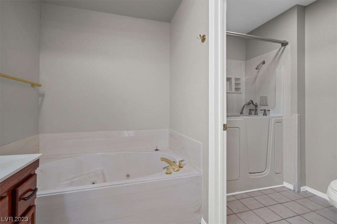 Separate jetted soaking tub and step in shower.