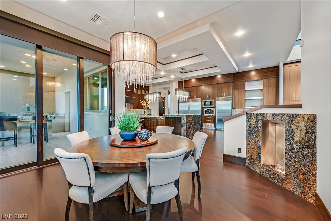 Breakfast area with dazzling light fixture, fireplace, and sliding doors to backyard.