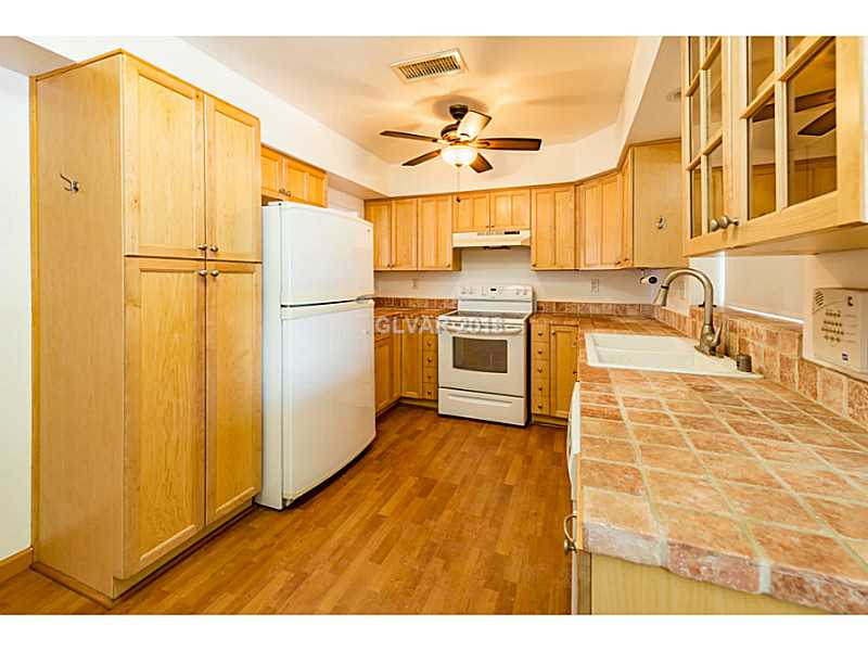 Kitchen. Beautiful kitchen with tile counters, wood laminate flooring, custom cabinets