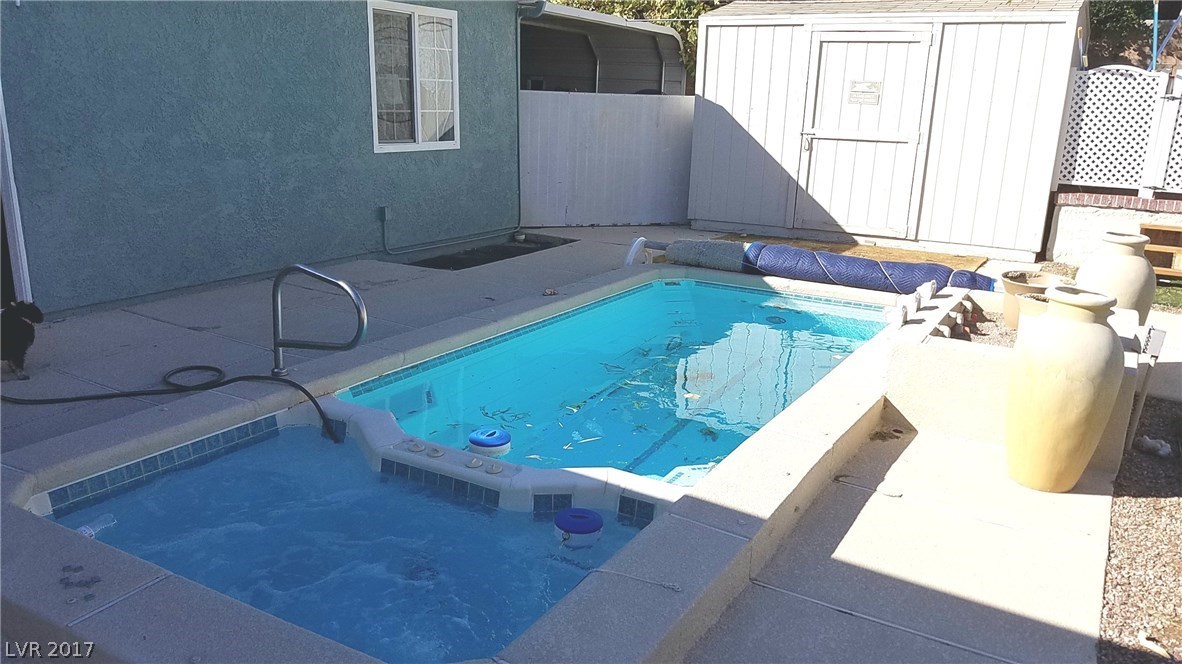 Enjoy the heated spa in one end.  Swim laps against the current in the larger section! Very efficient use of water and space.  Note the cover for the pool is on the roller at the end.  Large Storage Shed also.