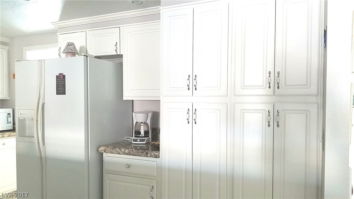 Double pantry for extra storage.  Crown molding around the top of the cabinets all around the kitchen.  So light and bright!  Great for seeing what you're doing.