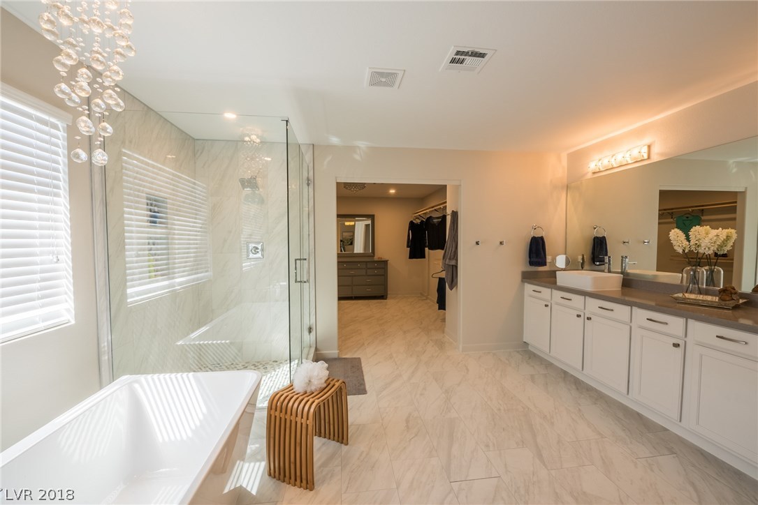 The luxury doesn't stop there, because a few steps away you will enter this luxurious spa-like master bathroom with gorgeous stand-alone tub, custom glass surrounded shower with rain shower head, extra long vanity with quartz counter tops, custom tile floors & elegant chandelier.