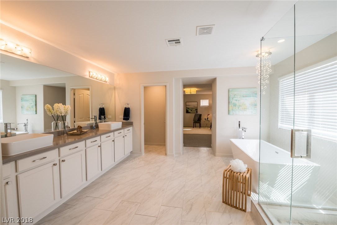 Custom shower offers pebble tile flooring.  Porcelain basin sinks & upgraded hardware on the cabinetry adds just a little more of that custom touch.