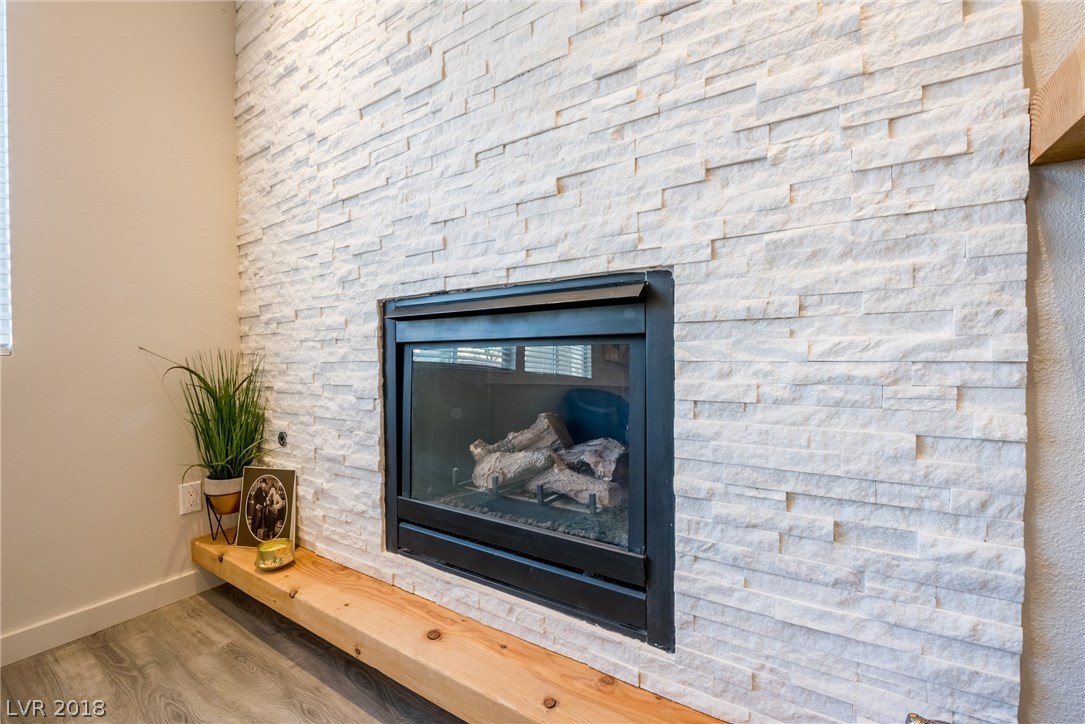 Absolutely stunning stone gas fireplace, with custom wood mantle & LED lighting.  Really makes the room pop & ads so much luxury.