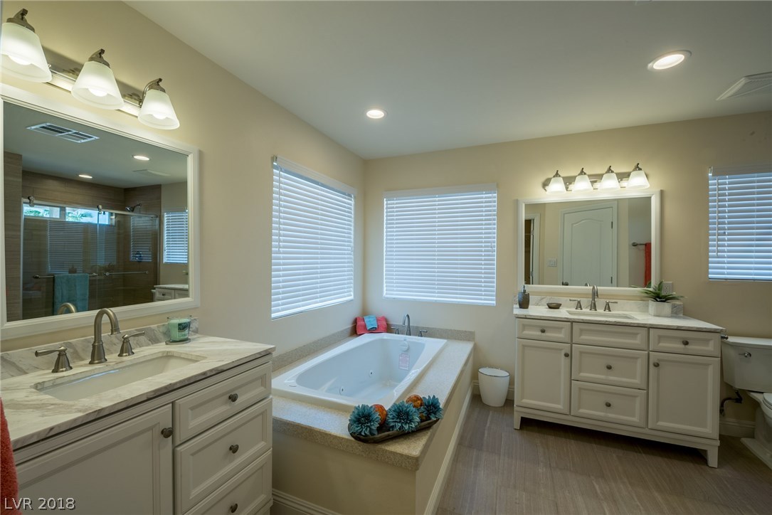 Lots of natural light offered in this master suite with all the windows.  Large soaking tub, plus large walk-in shower.  Separate dual sinks & vanities, and custom tile floors.