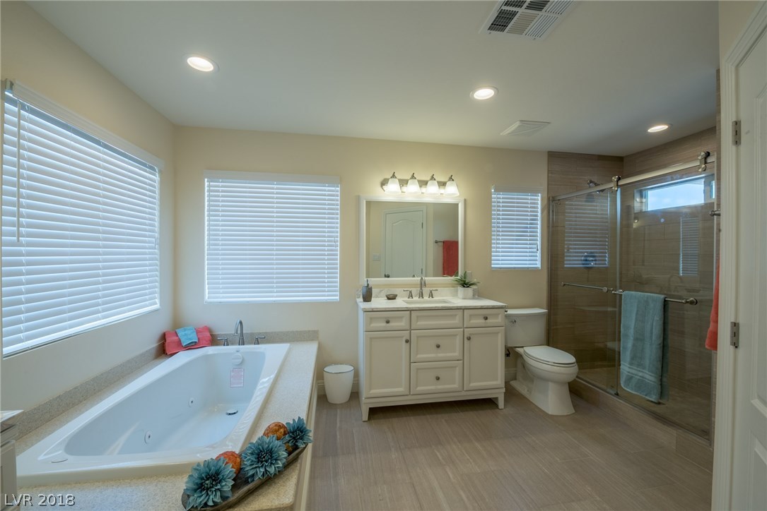 Soaking tub offers jacuzzi jets.  Separate shower offers custom tile surround and natural light through the window above.