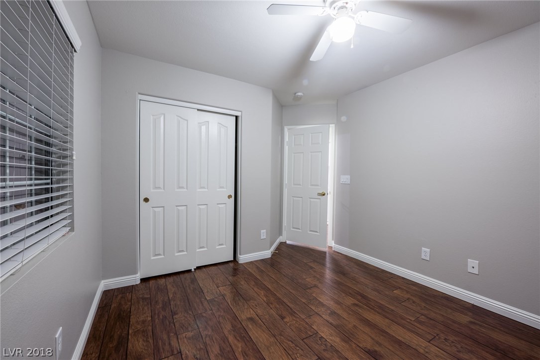Third bedroom offers dark wood floors, lots of closet space, ceiling fan, and lots of natural light.