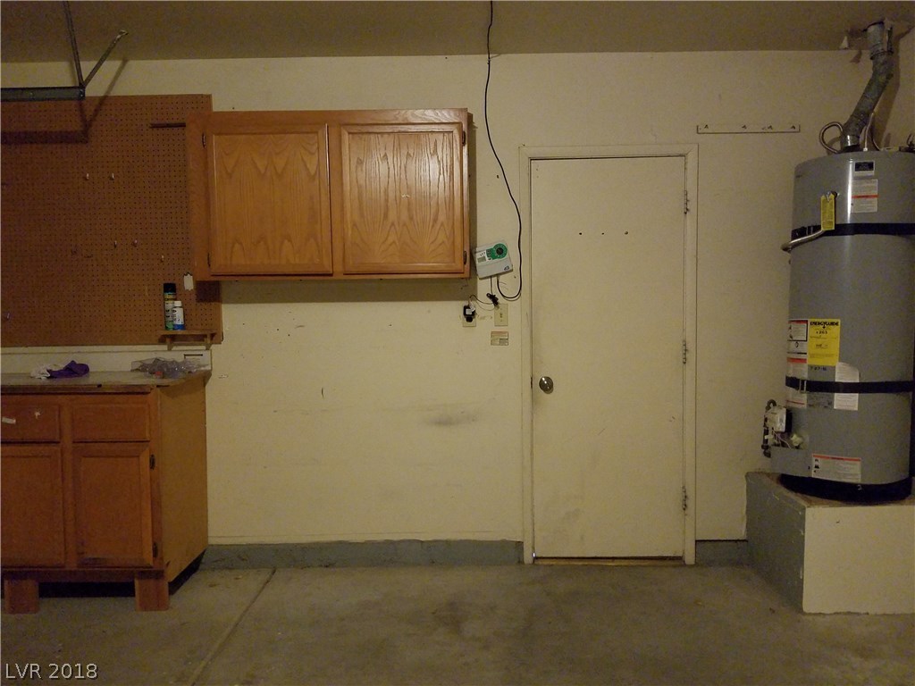 Cabinets, side door, and strapped water heater complete the garage