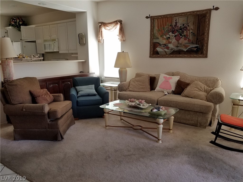 Living room in front of house, open to kitchen.  Custom cabinet is under the breakfast bar.