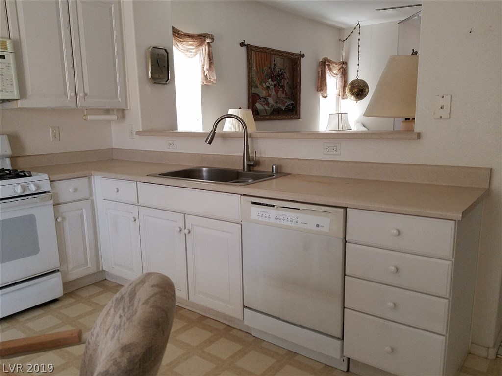Double stainless steel sink and dishwasher included, plus more cabinets and drawers.
