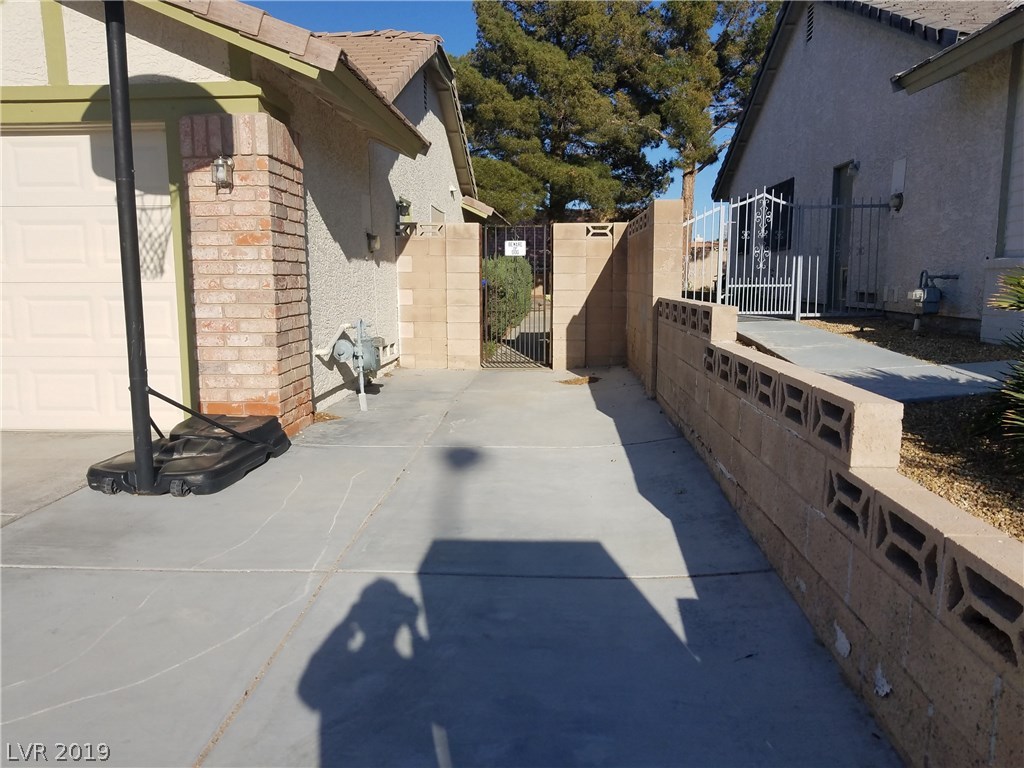 Extra space, with an extra tall gate to the back.  Sidewalk extends all the way to the elevated patio under the pine tree.