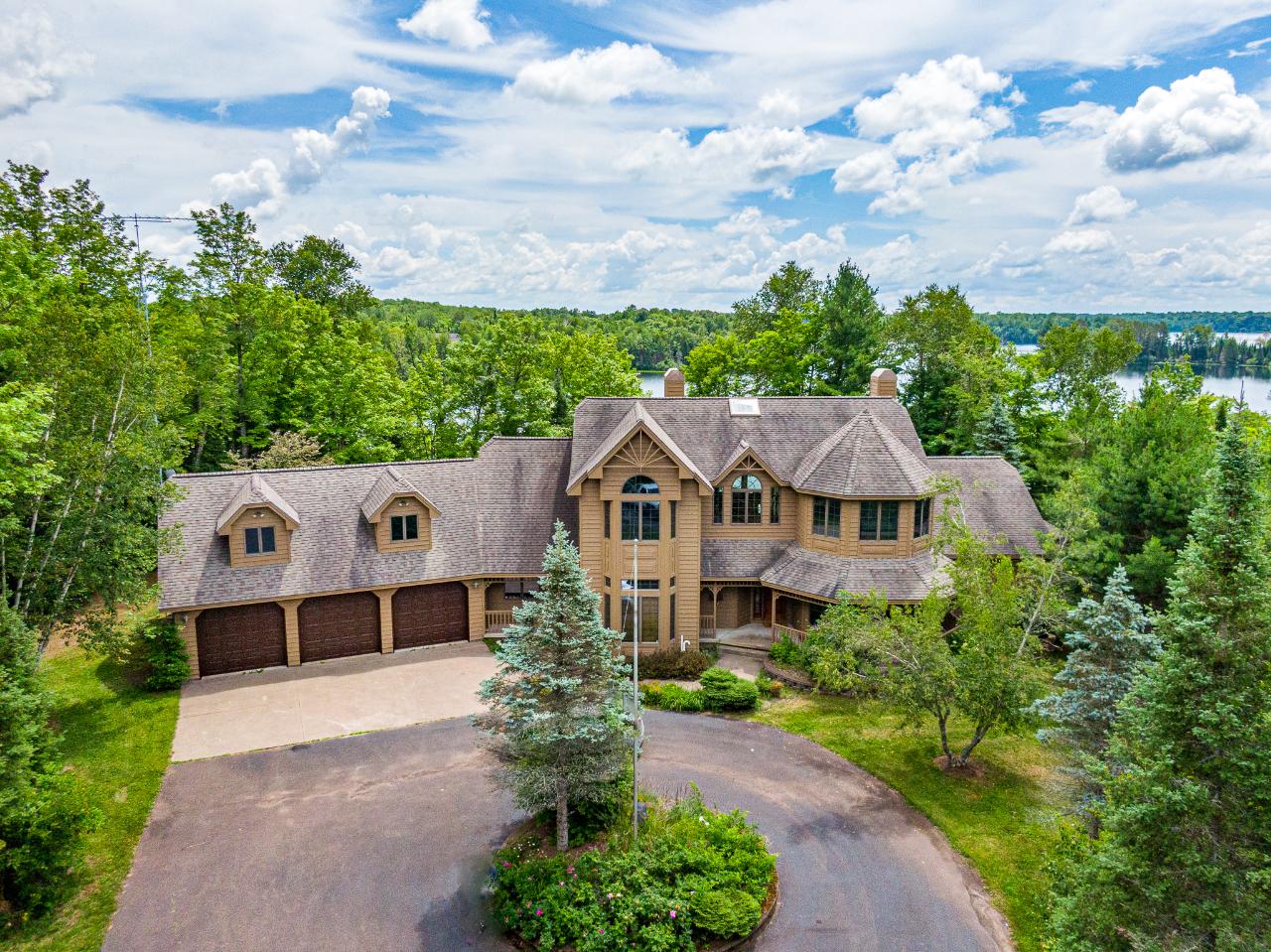 REDUCED! Harris Lake Luxury Estate on 2.24 acres w/211' of sand frontage! Completely updated including painting inside and out, new flooring, new fixtures, new furnace and much more. Great AirBnB opportunity with over $130K in bookings! The grand entrance leads to the great room w/ 28' high ceiling & massive Lannon stone FP. Chef's kitchen features a double oven Viking range, Sub-Zero refrigerator, wine cooler, cabinetry of the highest quality & much more! The master suite includes a 2-way FP, huge bath, WIC, Jacuzzi tub, separate shower & large vanity. Full bath, luxurious wet bar room/den, 1st floor laundry, formal dining room, large BR & much more round out the main floor. Upstairs, there's 4 more BRs & 2 full baths. Breathtaking water and woods views from every room! Massive lower level is beautifully finished as a huge family/rec room with W/O to patio area. Spacious 3-car att garage w/huge bonus room above for extra sleeping! Truly a MUST SEE for discriminating buyers!