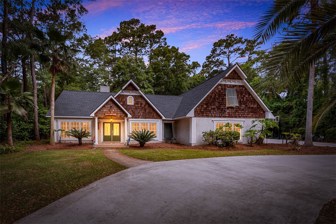 Located in beautiful Hampton Point on the North end of St. Simons Island, this large custom-built home features the primary and 2 more bedrooms on the main level plus a two-bedroom guest suite upstairs.  The main living area features a great room with vaulted beamed ceilings, Heart of Pine floors, and a wood-burning fireplace. Large sunroom overlooks the large, almost acre, lot.  The kitchen features double conventional/convection ovens, an island, and a breakfast bar that opens to the breakfast room. A  large, custom workshop, 48' X 24'X16' tall, for RV, large boat, extra auto storage, OR equipment storage. 15 min. to restaurants & shopping. This home has been meticulously maintained & is move-in ready.
