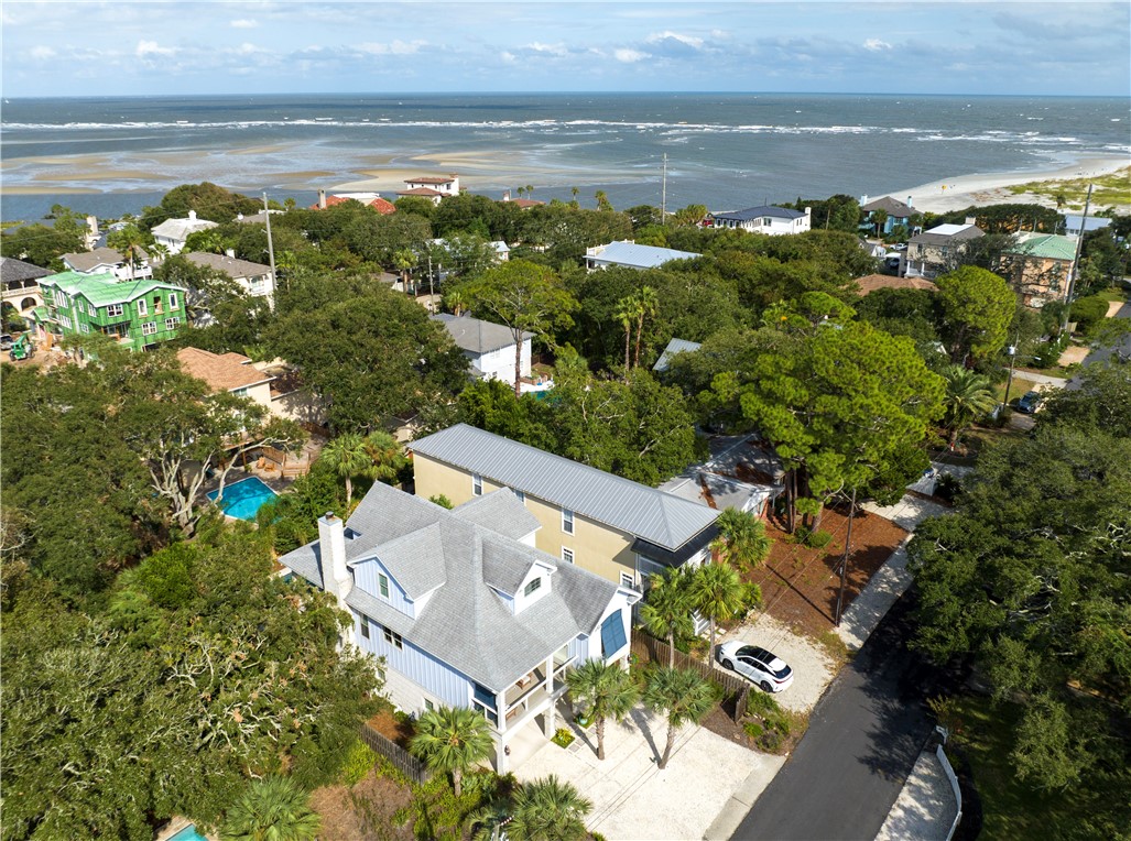 This custom 4 bedroom and 4 bath home is located in the desirable East Beach neighborhood on St. Simons Island.  1 house away from the marsh with marsh views and 7 houses away from the beach, this home was built by Bill Phelan with the highest standards of design and quality. The layout is open and intelligent with high ceilings and bright surfaces. The main level is designed with foyer, open kitchen, dining room and living room as well as a primary bedroom suite, guest bedroom and bath and two large porches. The elevator or a staircase leads to the upper or lower level.  There you will find a second living area and two large additional bedrooms with ensuite baths. In the pool area with sun decks, you also get the desired privacy and a large pool, which is fun for everyone.  On the ground level, you will find two garage bays, one which is oversized for bike and golf cart storage plus an additional unfinished room off the lower terrace.  Authentic barn wood throughout, the home feels charming.  Currently a primary residence, but would make an exceptional vacation rental or second home.  Please check out or video and virtual tour.