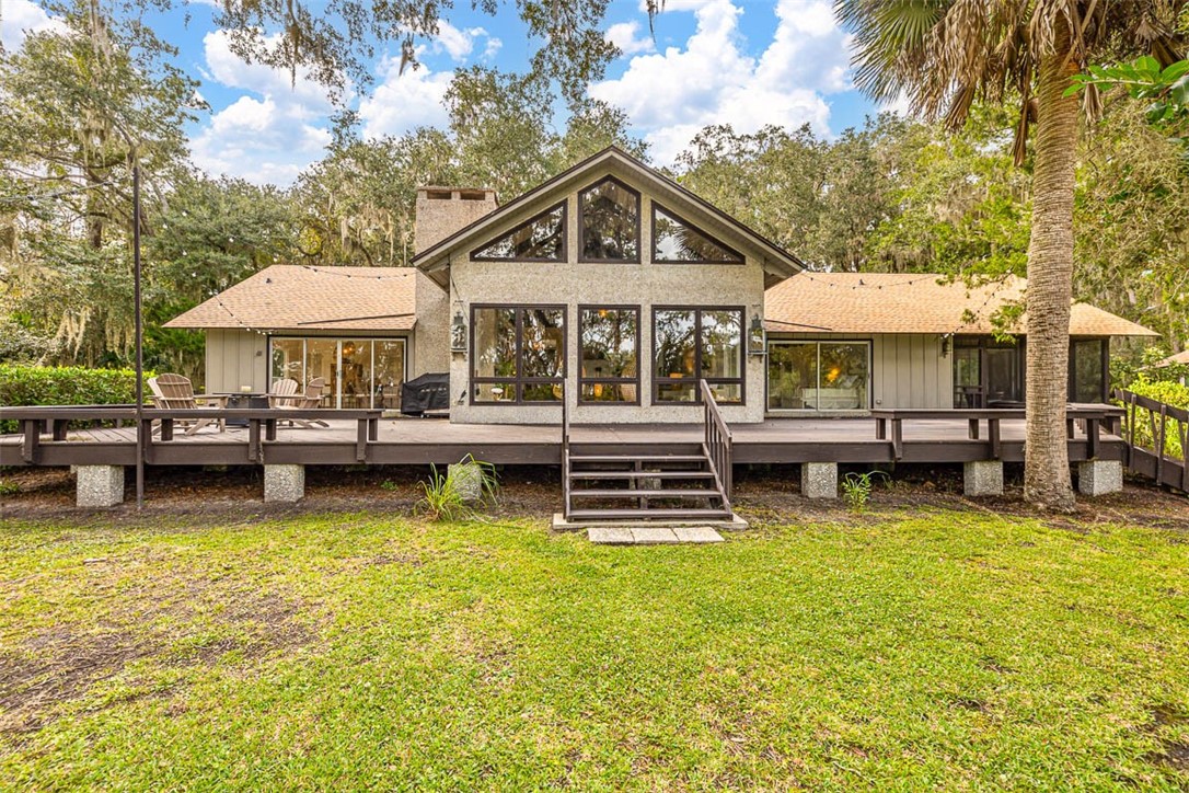 Situated within a nature preserve, this property offers a tranquil setting unlike any other. This stunning home, located on the north end of St. Simons Island, presents a wonderful opportunity for nature lovers seeking a special place to call home. Designed by Lamar Webb, this home features exquisite pecky cypress walls and pegged oak wood floors, demonstrating warmth and sophistication. The open floor-plan allows for seamless flow between rooms, including a captivating great room boasting a vaulted cathedral ceiling with beautiful beams and two tabby fireplaces. This property is full of natural light, thanks to an abundance of large windows that provide spectacular views of the surrounding nature and wildlife. Additionally, a wrap-around deck invites you to breathe in the fresh air while admiring the scenic beauty. With two bedrooms and a loft that can serve as a bedroom or an office, this house offers versatility to fit your needs. Notably, this property is a rare find as it is surrounded on all sides by a permanently protected natural area owned by the St. Simons Land Trust. Complete with incomparable privacy, this one-acre tract is a unique gem that distinguishes itself from all other properties on the island. Don't miss this extraordinary opportunity to embrace a lifestyle harmoniously blended with nature in this remarkable house.
