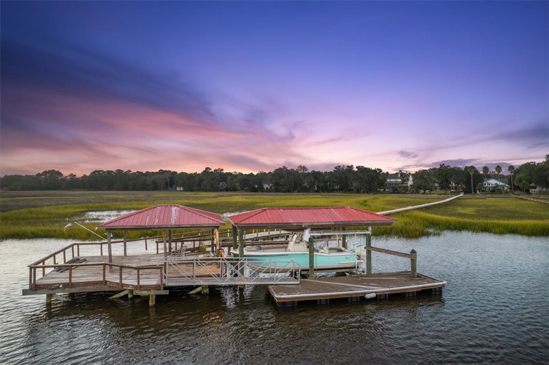 Waterfront paradise! 4-bed, 4½-bath brick home on a .59-acre lot in upscale Royal Oaks, Brunswick. Enjoy the best of both worlds with a private lake out front and a deepwater coastal river out back. Boaters' haven with a 600-ft pier, covered dock houses, boat lift, and floating dock. Relax in the heated saltwater pool, spa, or under the gazebo. Entertain in the spacious kitchen, formal dining, media room, and family room with a fireplace. Master suite with fireplace, walk-in closet, and stunning views. Solar-powered with backup systems. Ideal coastal living!  For enjoying the coastal lifestyle, there’s no better combination of comfortable, modern interior, scenic natural landscape, and the lure of the water. Whether you’re a freshwater or saltwater fanatic, this maritime dream house has you covered