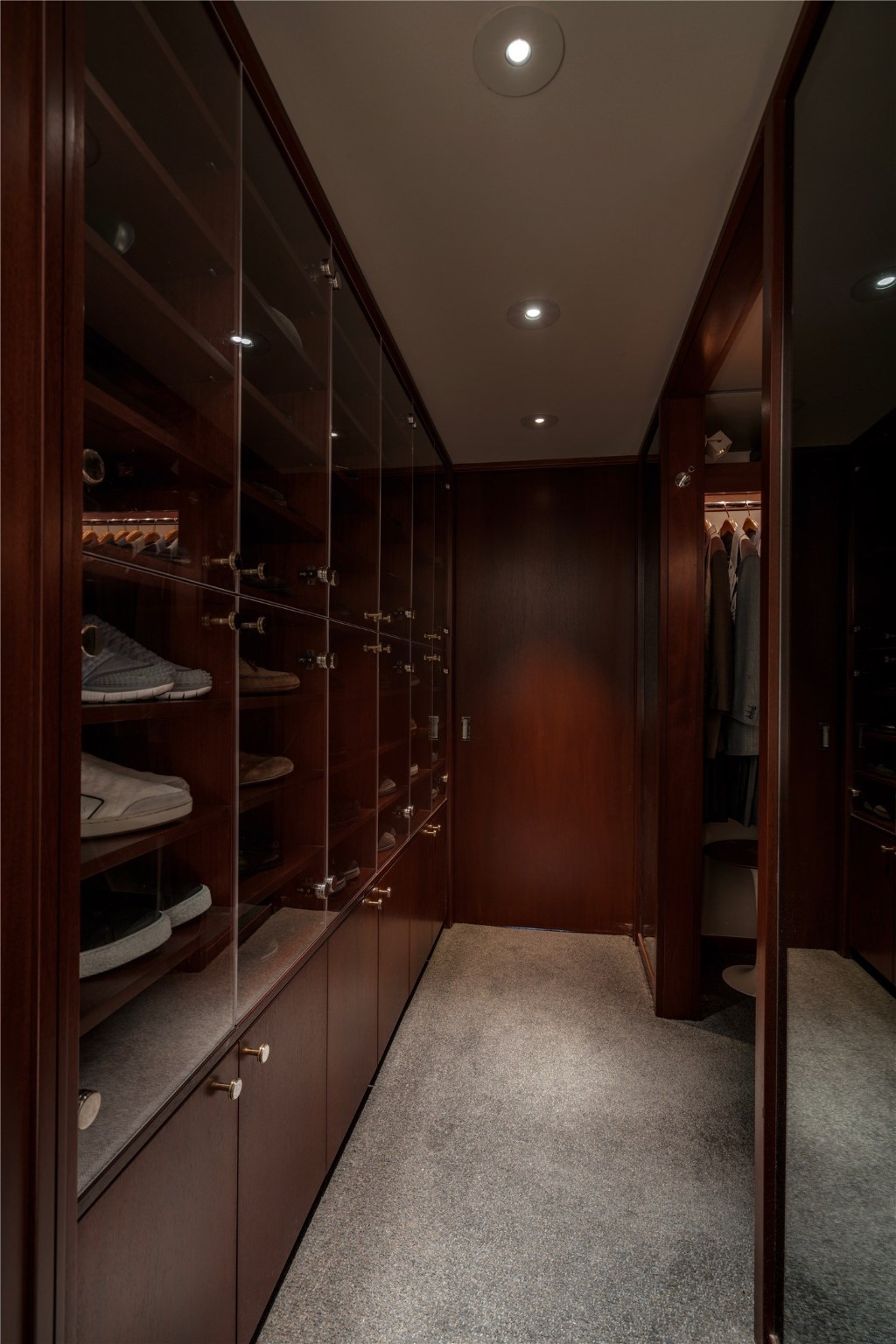 Hallway includes built-in shoe and purse shelving wall with lucite and cherry wood fronts.