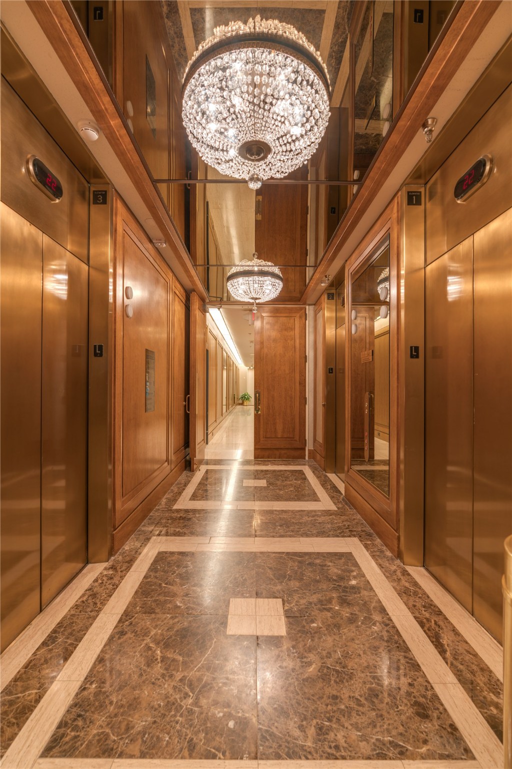 Elegant elevator lobby with wood paneling, crystal chandeliers and marble floors. Three elevators assure you will be whisked to your suite quickly.