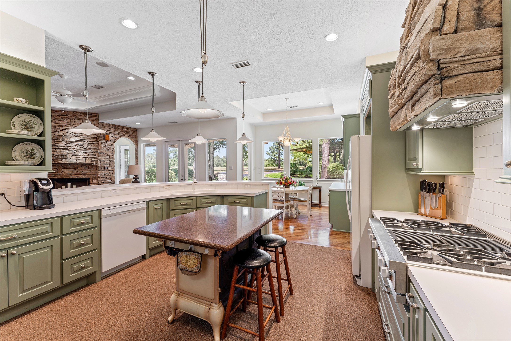 The kitchen provides a generous amount of storage and counter space for preparing meals including a granite-topped antique wood-burning stove island with additional counter seating.
