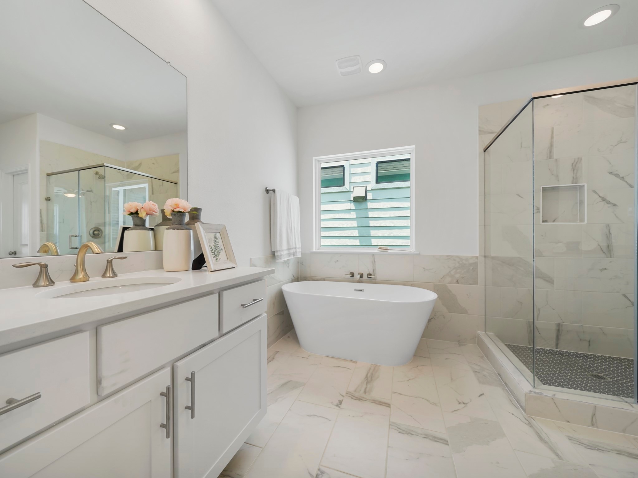 Step into the spa-like Primary Bath! The space features two vanities, custom cabinets, and stunning quartz countertops.