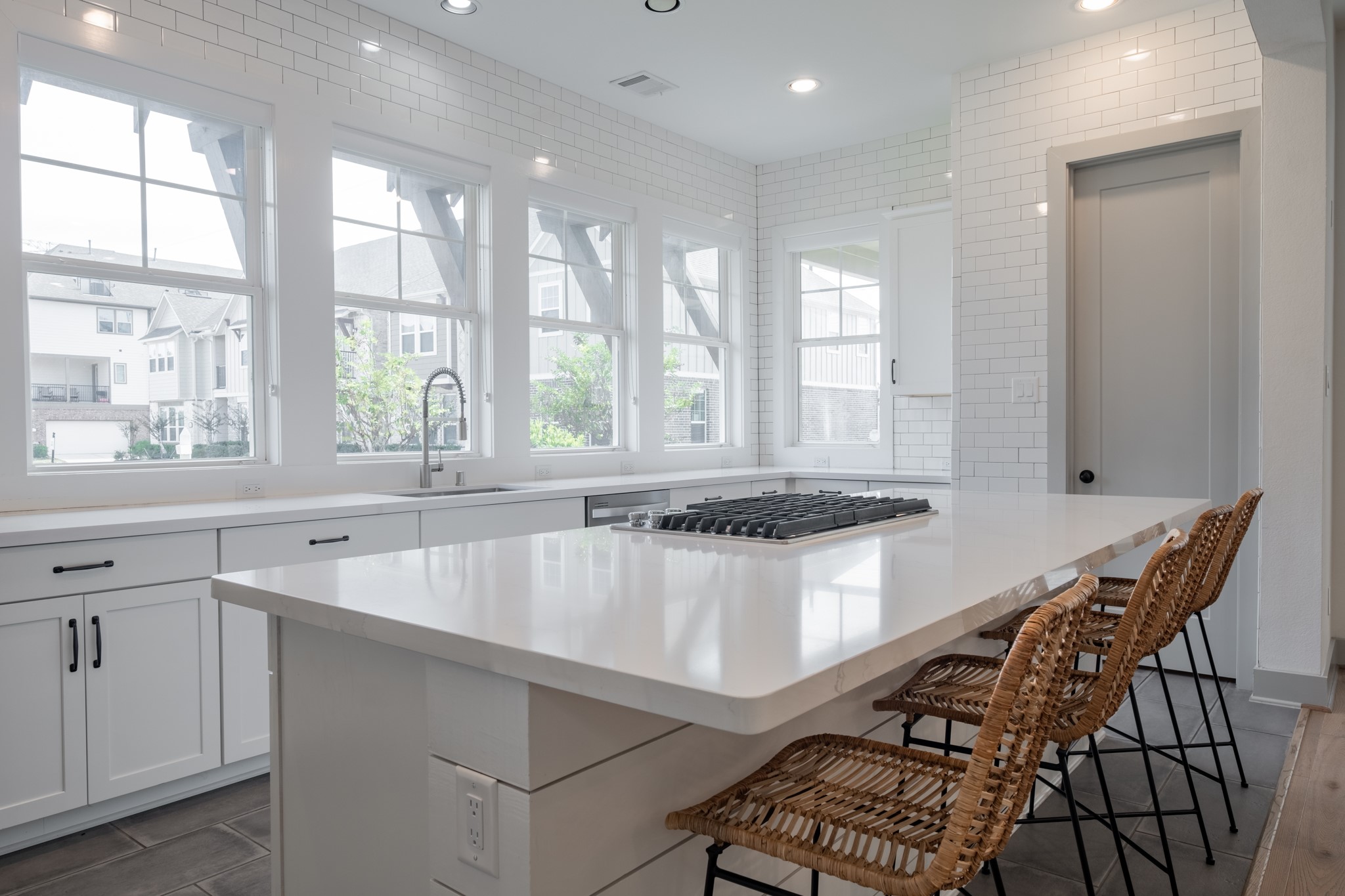 The kitchen is classically elegant with white quartz countertops and marbelized island