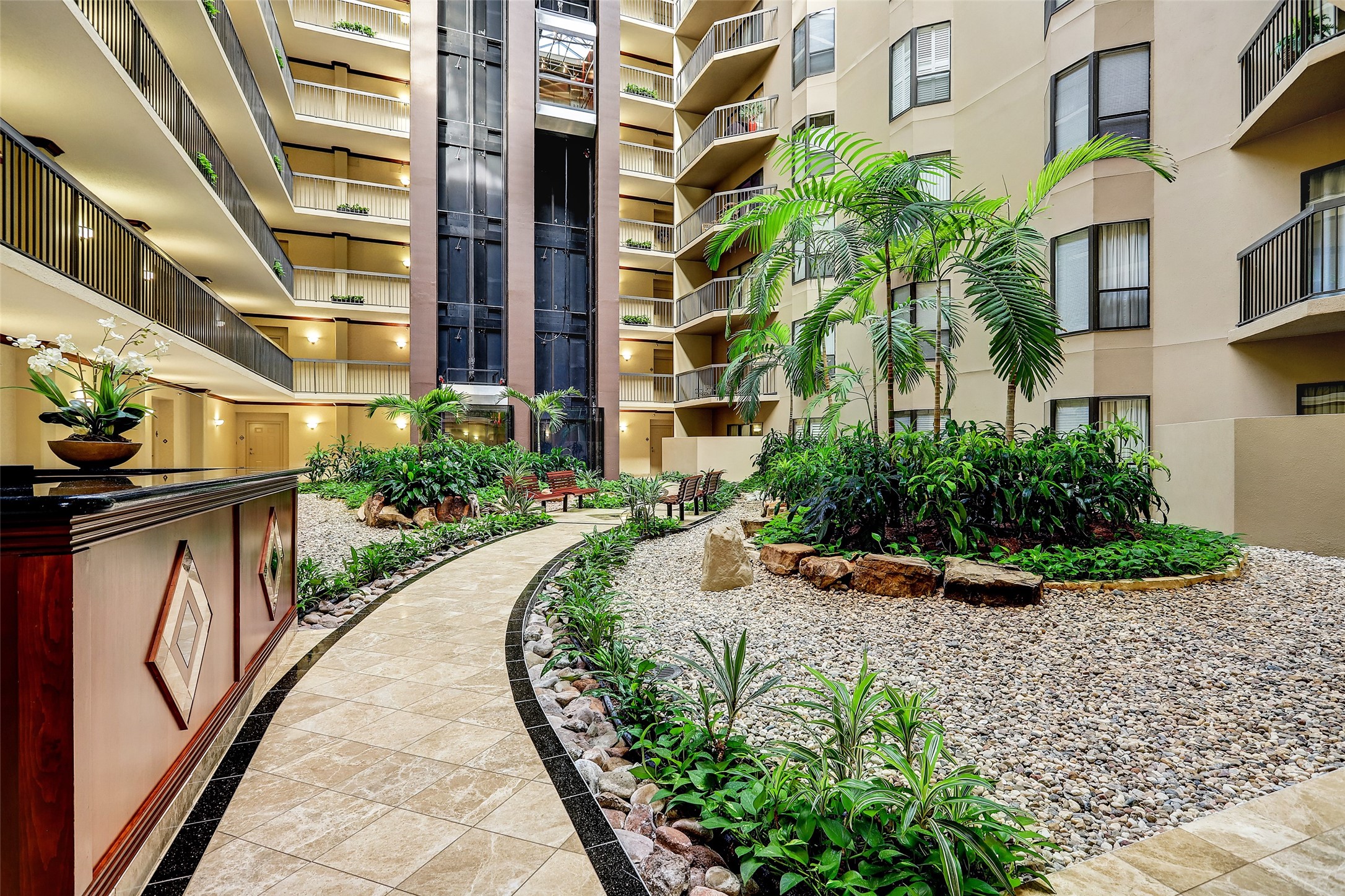 Atrium:  Filled with Alexander palms & tropical landscaping.