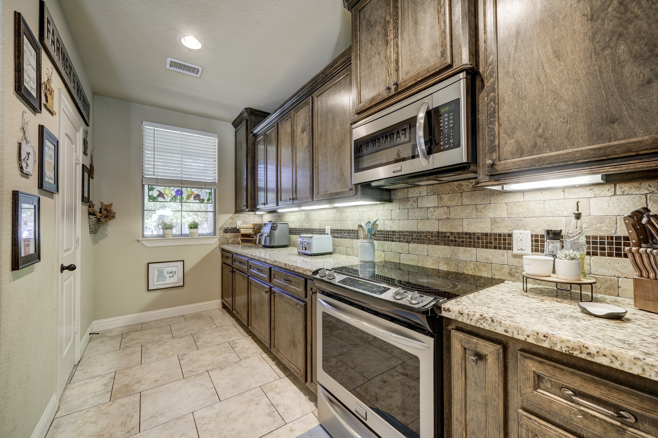 Stunning stone and tile work that make up the backsplash complement the cabinets and counter tops.