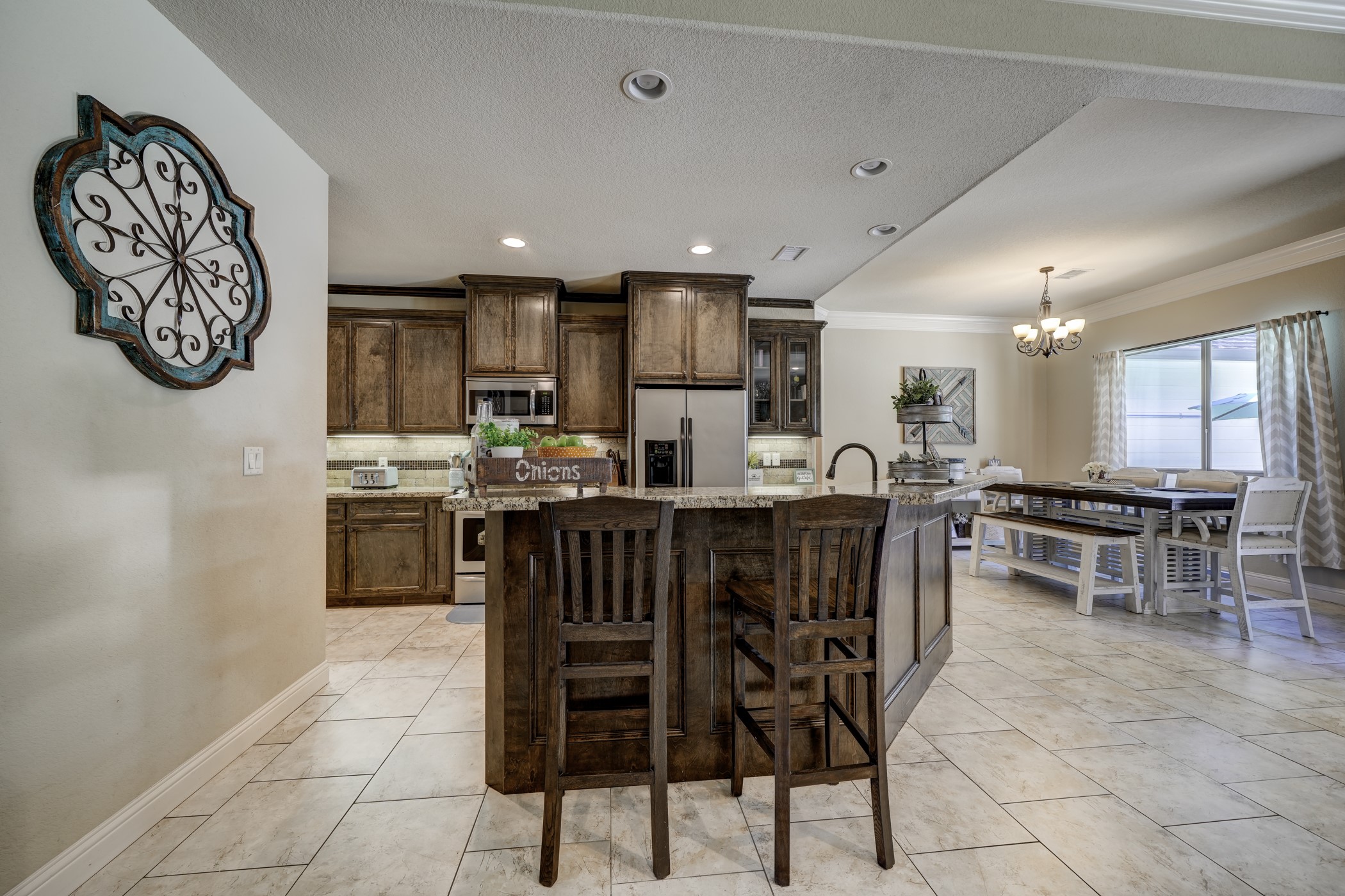 A breakfast bar offers relaxed seating while the nearby dining area provides plenty of space for a larger gathering.