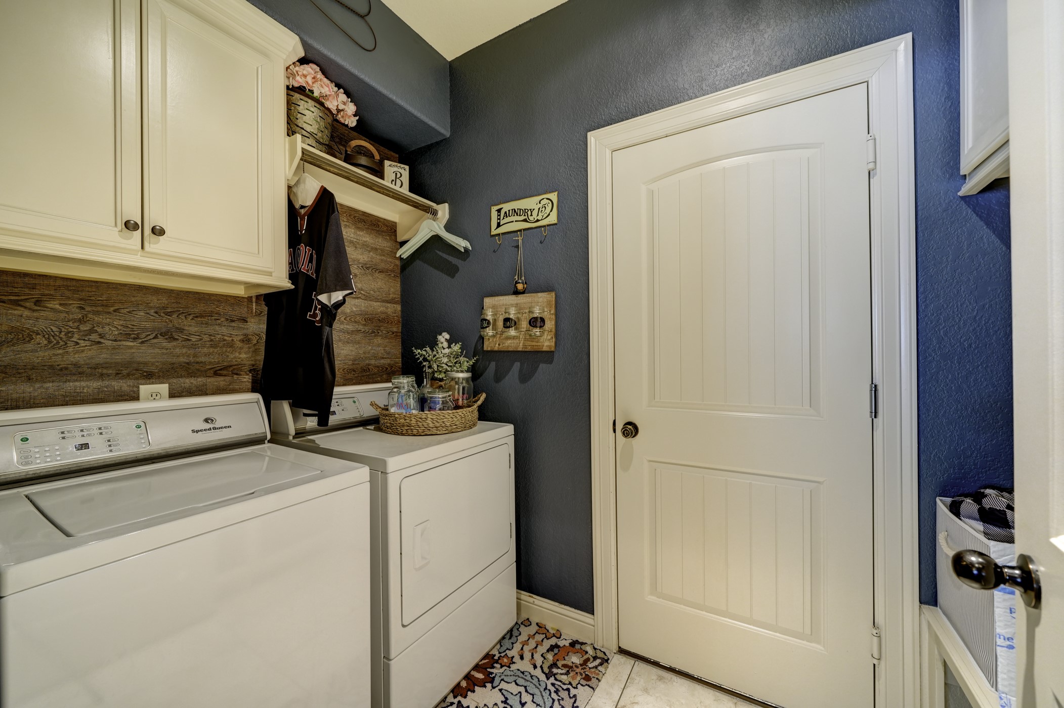 A charming laundry room/mud room includes extra storage.