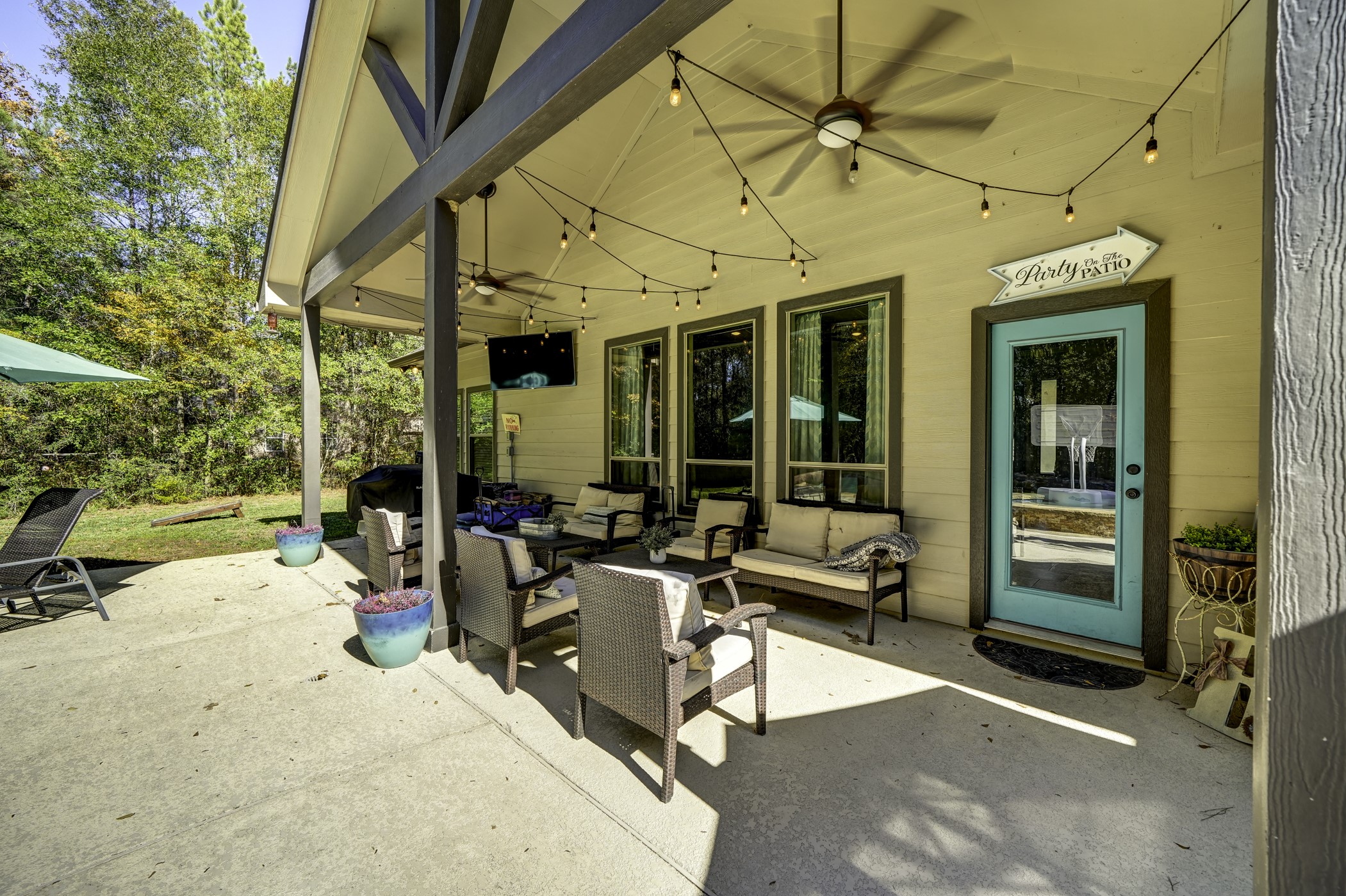 Head to the covered patio to enjoy the outdoors. A high roof with ceiling fans help to circulate the air on a warm day.