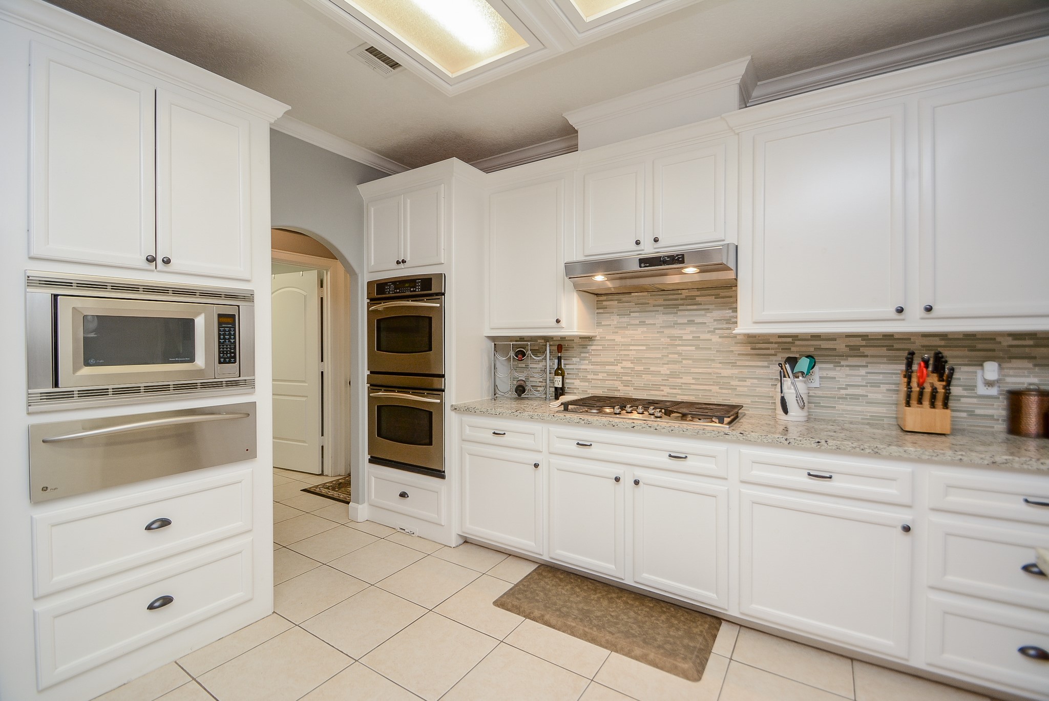 Kitchen with Granite Countertops, Stainless Steel Appliances, Double Convection Oven, Gas Cooktop, Built-In Microwave, Warming Drawer, Under-Counter Lighting, Dishwasher & Double Stainless Steel Sink.