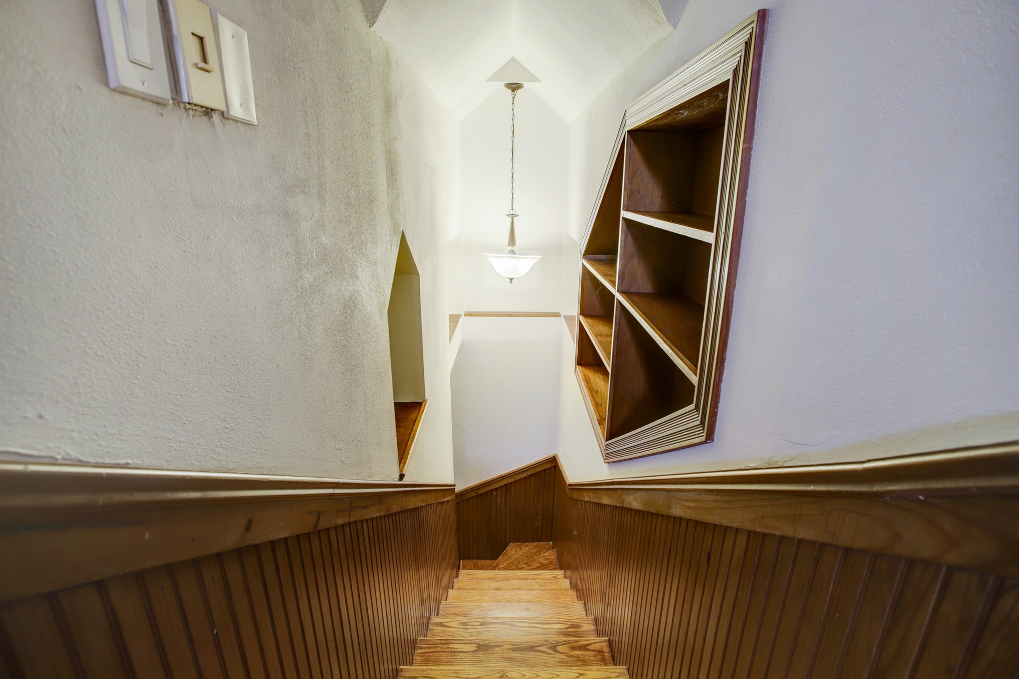 Charming architecture – staircase is adorned with a unique vaulted ceiling and art niche.