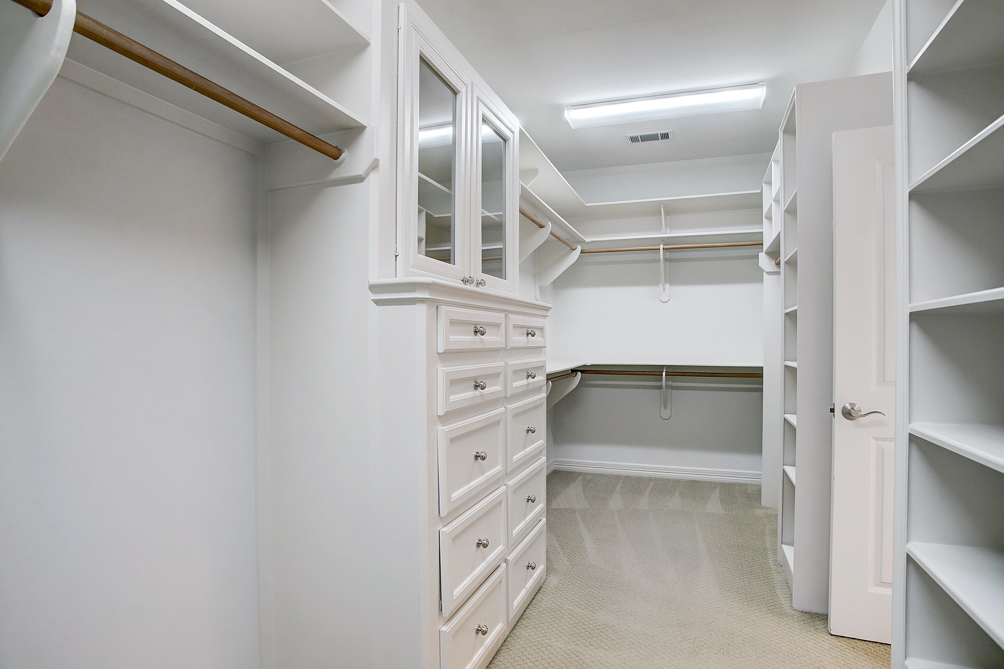PRIMARY CLOSET-  A huge closet with custom built-in drawers, cabinets and shelves is adjacent to the primary bath.