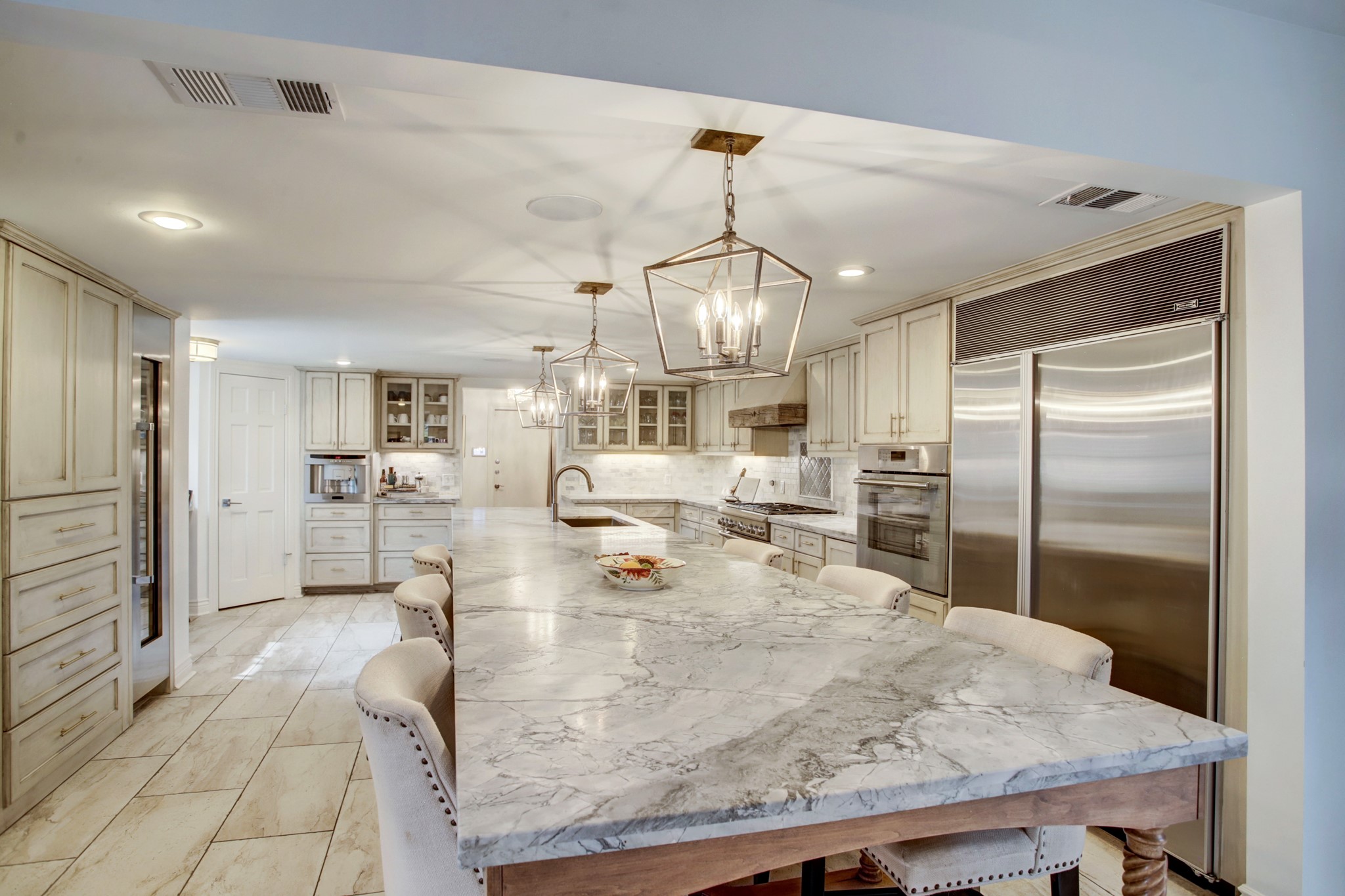Grand island kitchen with stainless steel appliances and  quartzite counter tops is a chef's dream