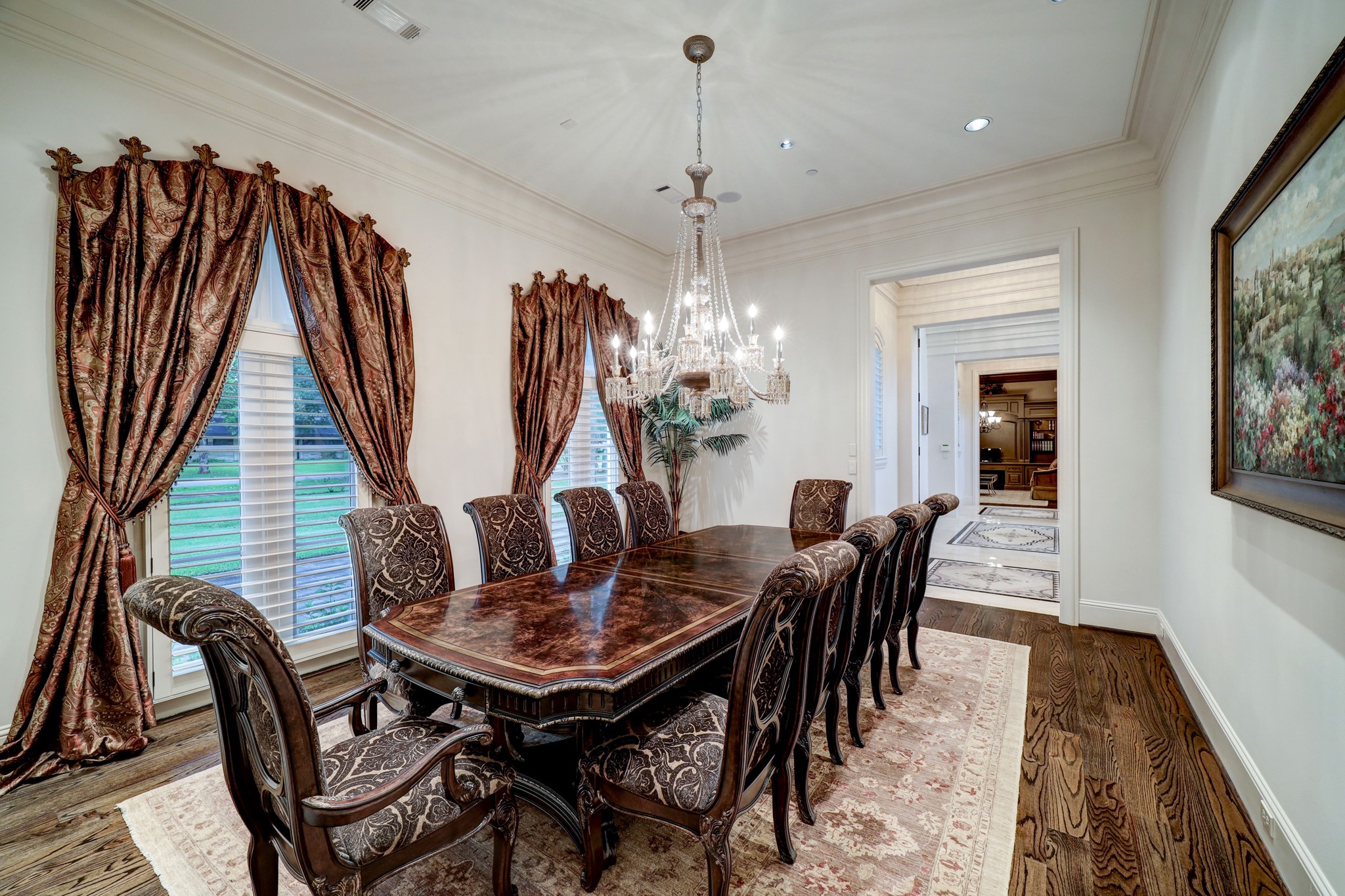 The Formal Dining Room is located just off the Entry and features hardwood floors, a hanging chandelier, crown molding and baseboards and access to the Kitchen via the Butler's Pantry.