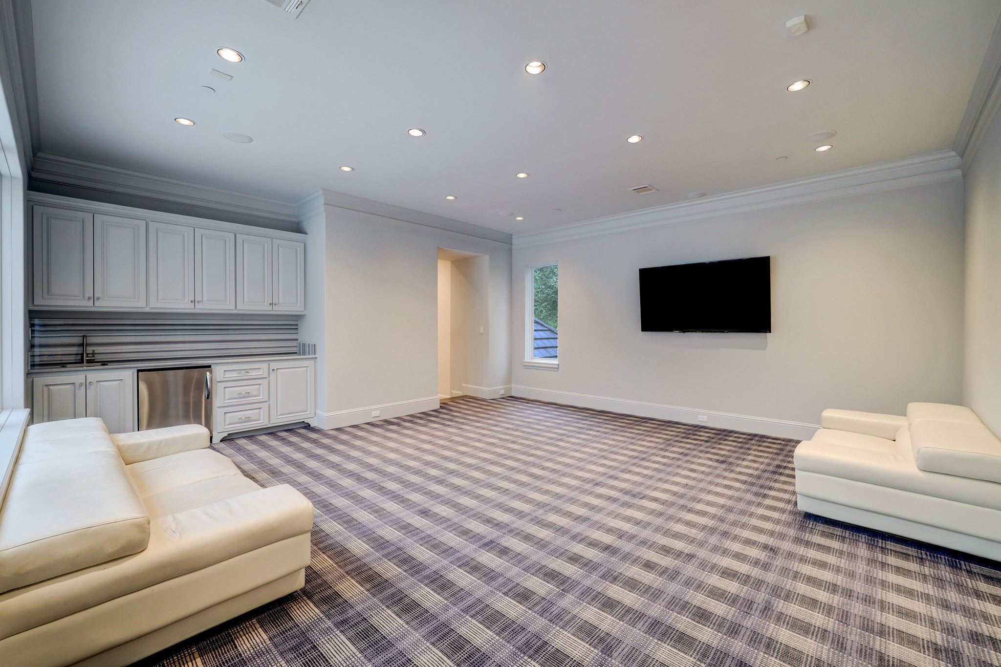 The Game Room is located upstairs and features carpet and a built-in snack bar with sink and cabinet storage.