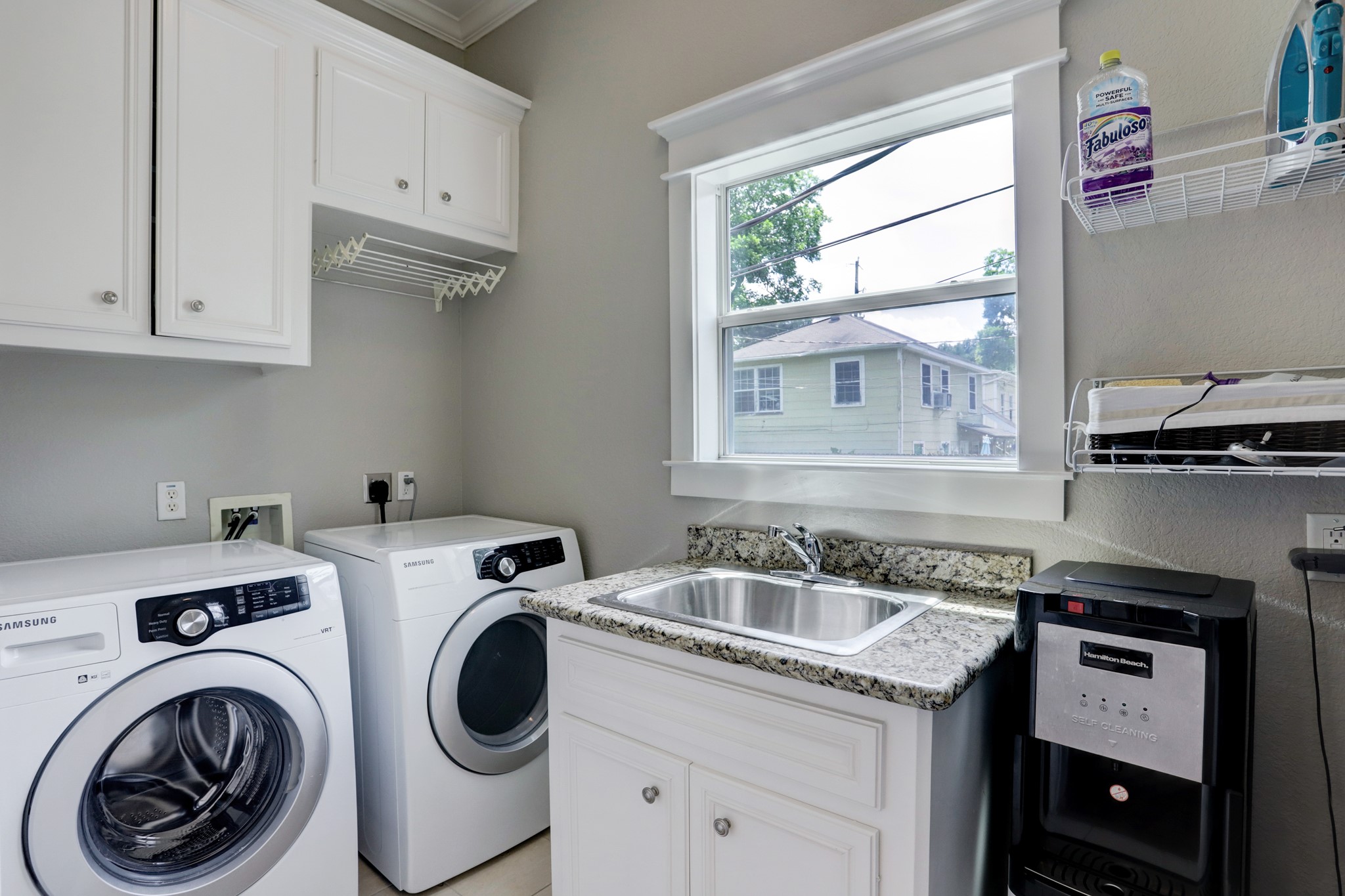 Utility room has plenty of storage and cabinet space along with utility sink.