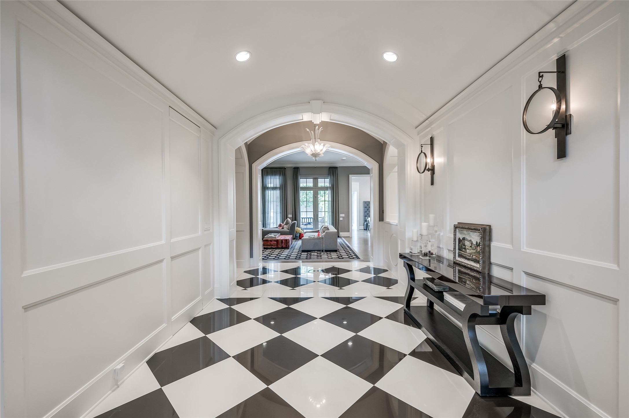[Foyer / Center Hall]
Beneath a barrel ceiling, paneled walls line the center hall that travels from the foyer to a cross gallery and family room at rear.