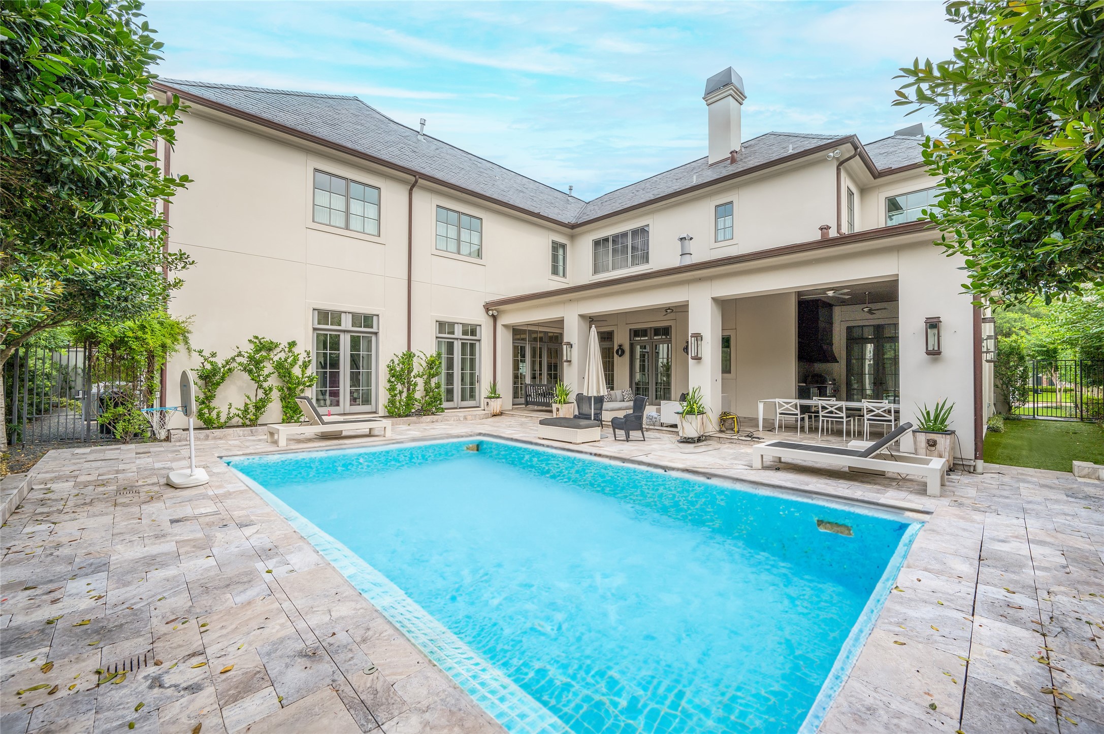[Rear Elevation]
A wide view of the pool, open patios, and expansive loggia.