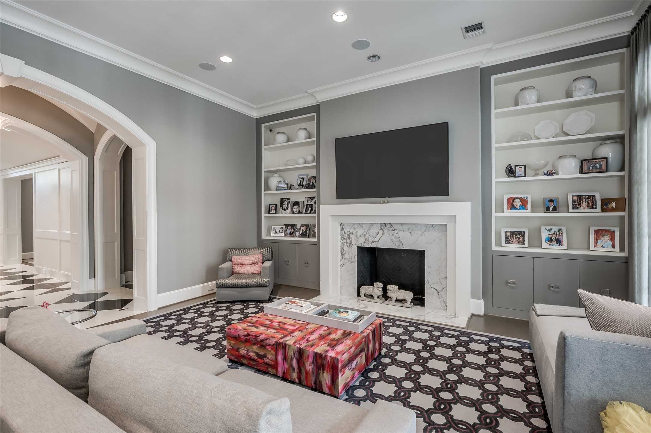 [Family Room]
Floor-to-ceiling book and storage cabinets flank the fireplace with marble surround and hearth. Center hall from foyer is shown at left.