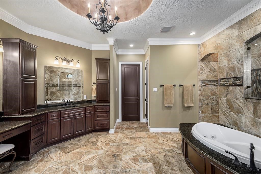 Spa like master bath with whirlpool tub, his and hers sinks, vanity area and enormous closet with island.