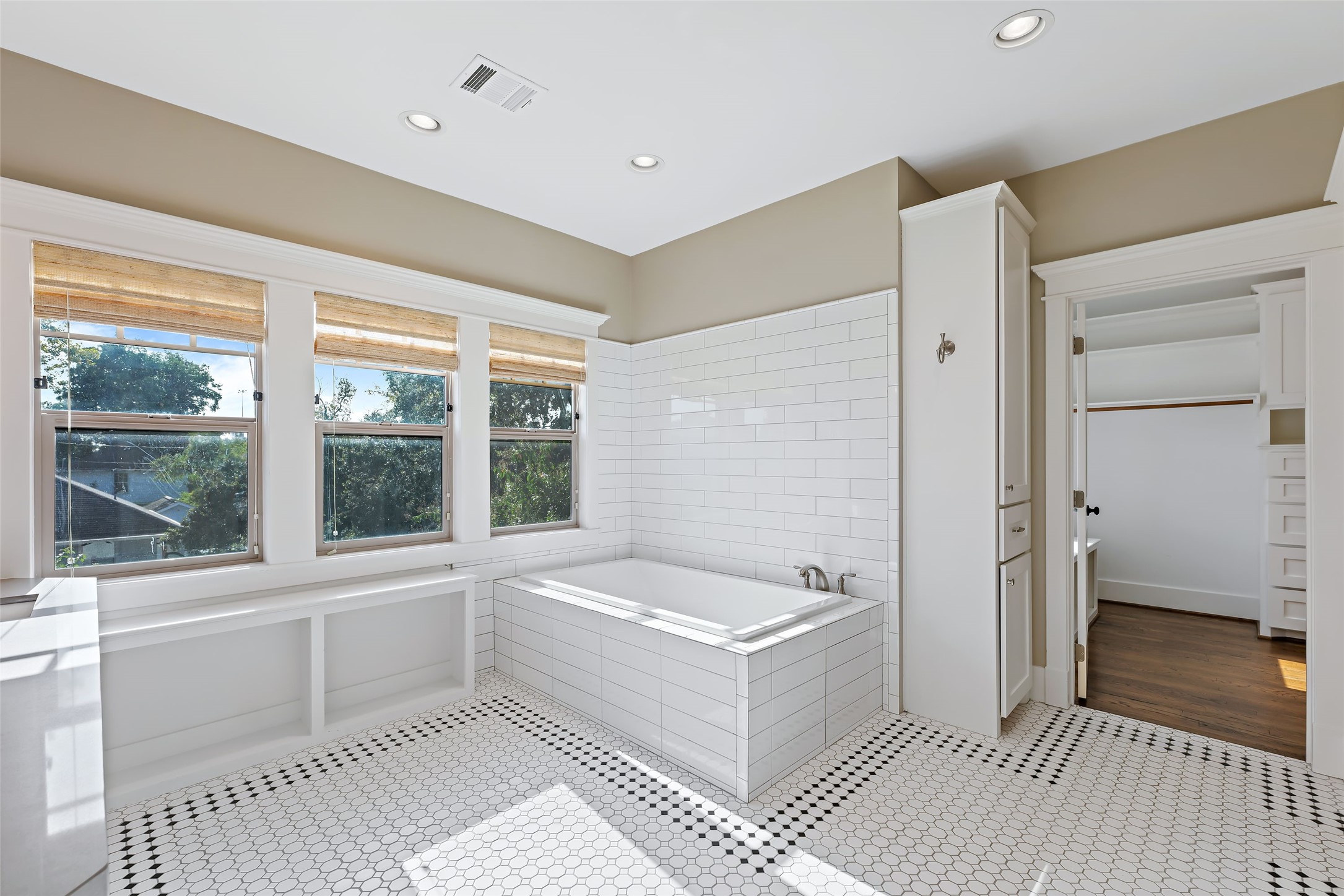 Stunning, light filled primary bath with soaking tub and separate shower, linen cabinet, closet.
