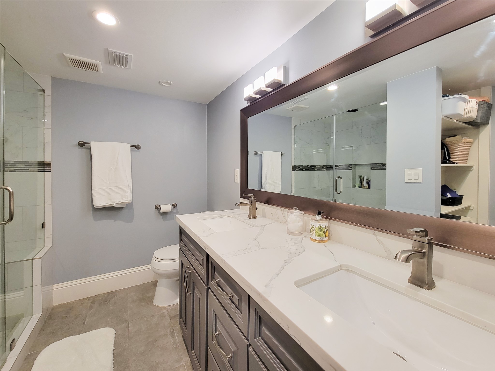 A beautiful new bathroom is designed with efficiency and functionality in mind. Double vanities with a durable and beautiful quartz countertop along with a large walk in shower with a built in bench are just a few well chosen design elements.