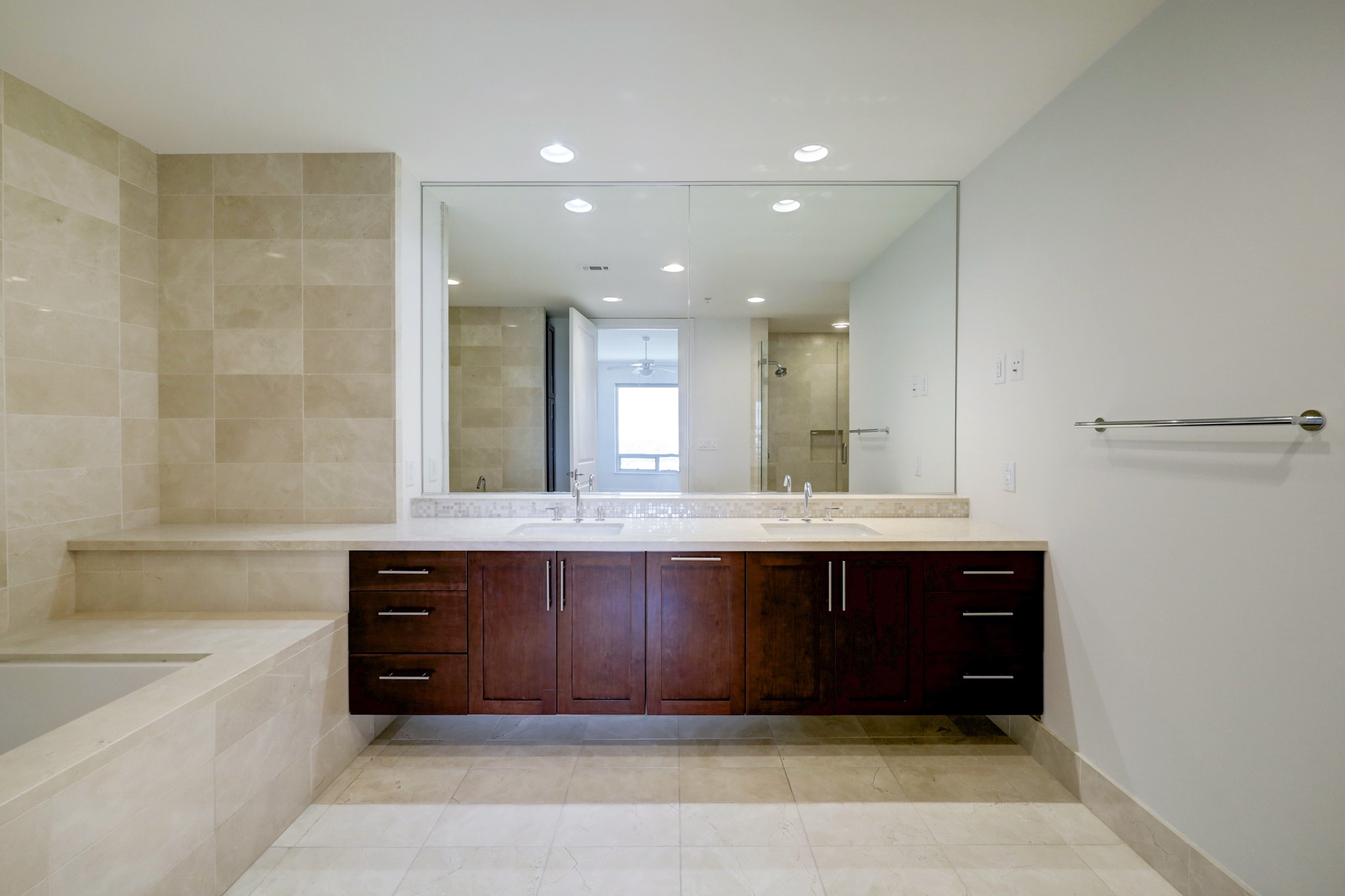 Let's take a tour of the Primary Bathroom.  Double sinks, ample drawer space and under sink storage with a built-in pull-out laundry drawer.  Marble topped counter and tub surround