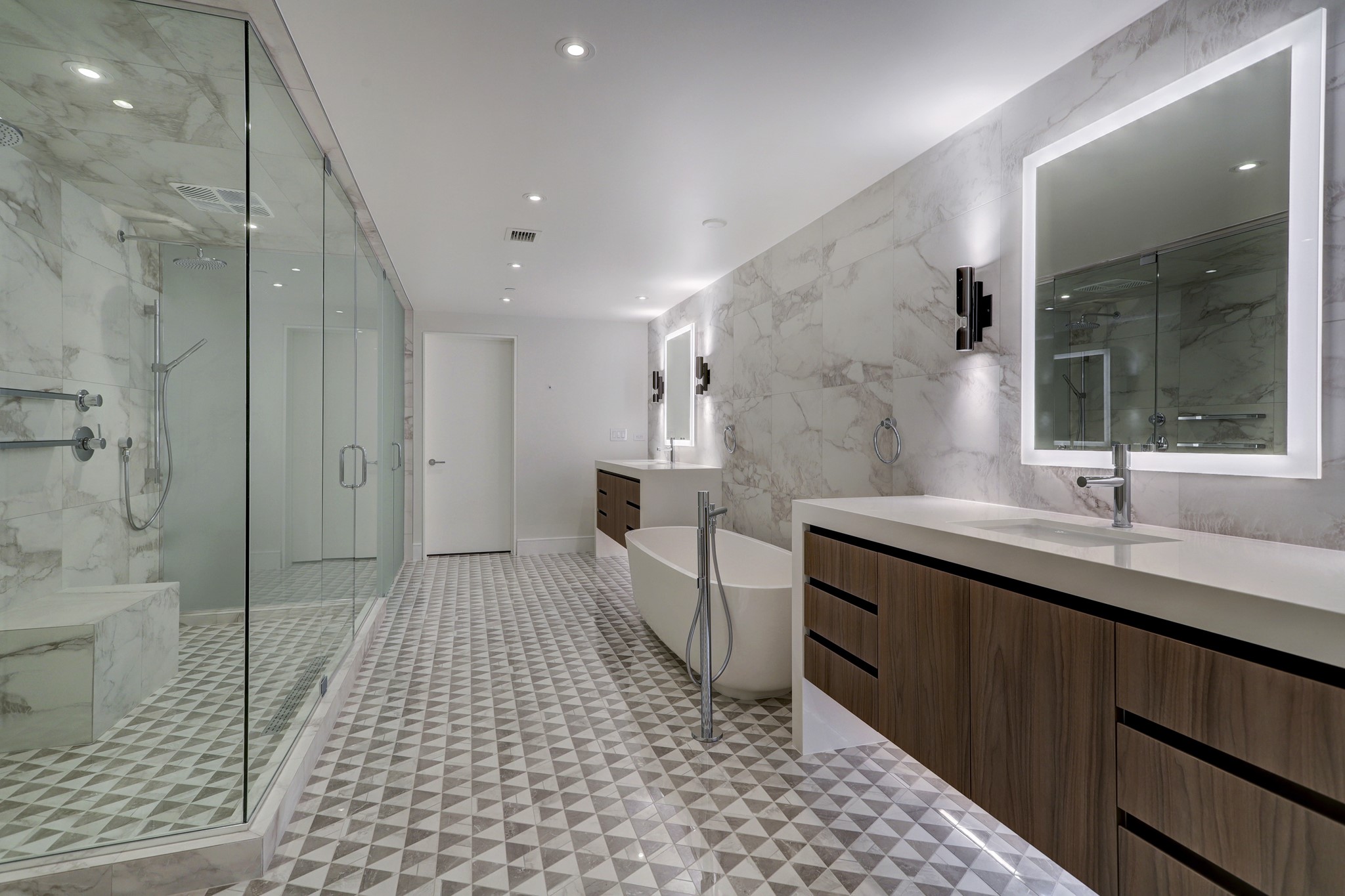 In the upper-level primary suite's spa bathroom, you'll find the same impressive fixtures and finish program as below, accentuated by lively Piemme tile.